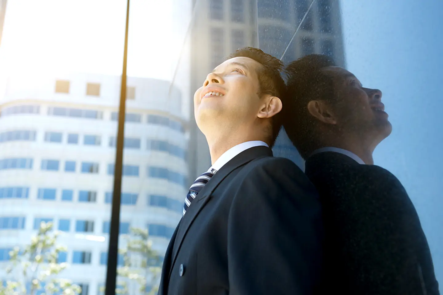 Hombre de negocios sonriendo y mirando hacia arriba