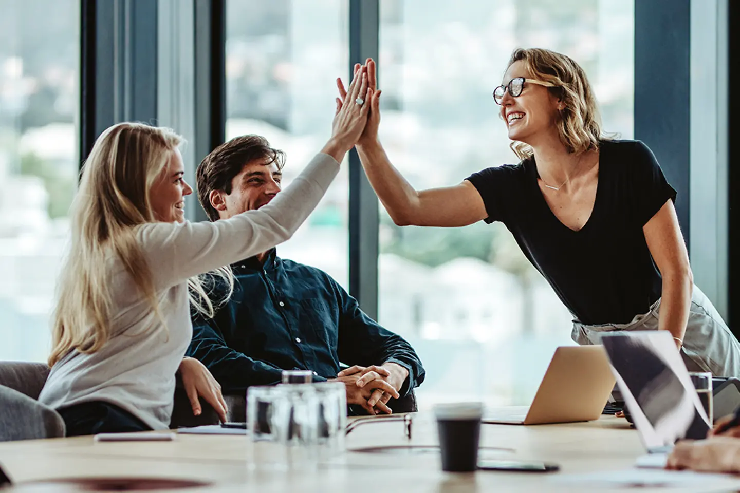 Team members celebrate a victory in a boardroom