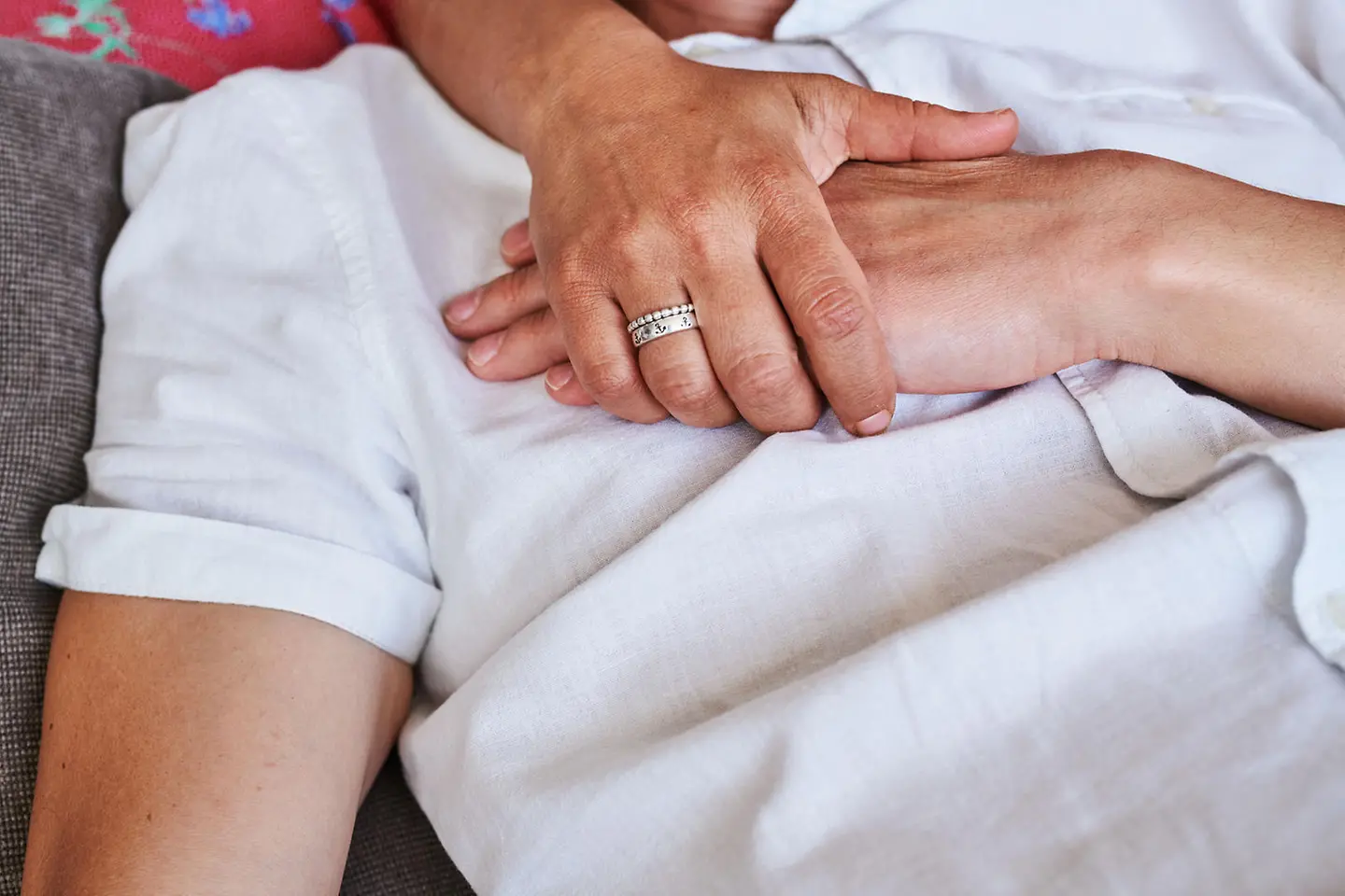 Hands hugging another person wearing a white shirt