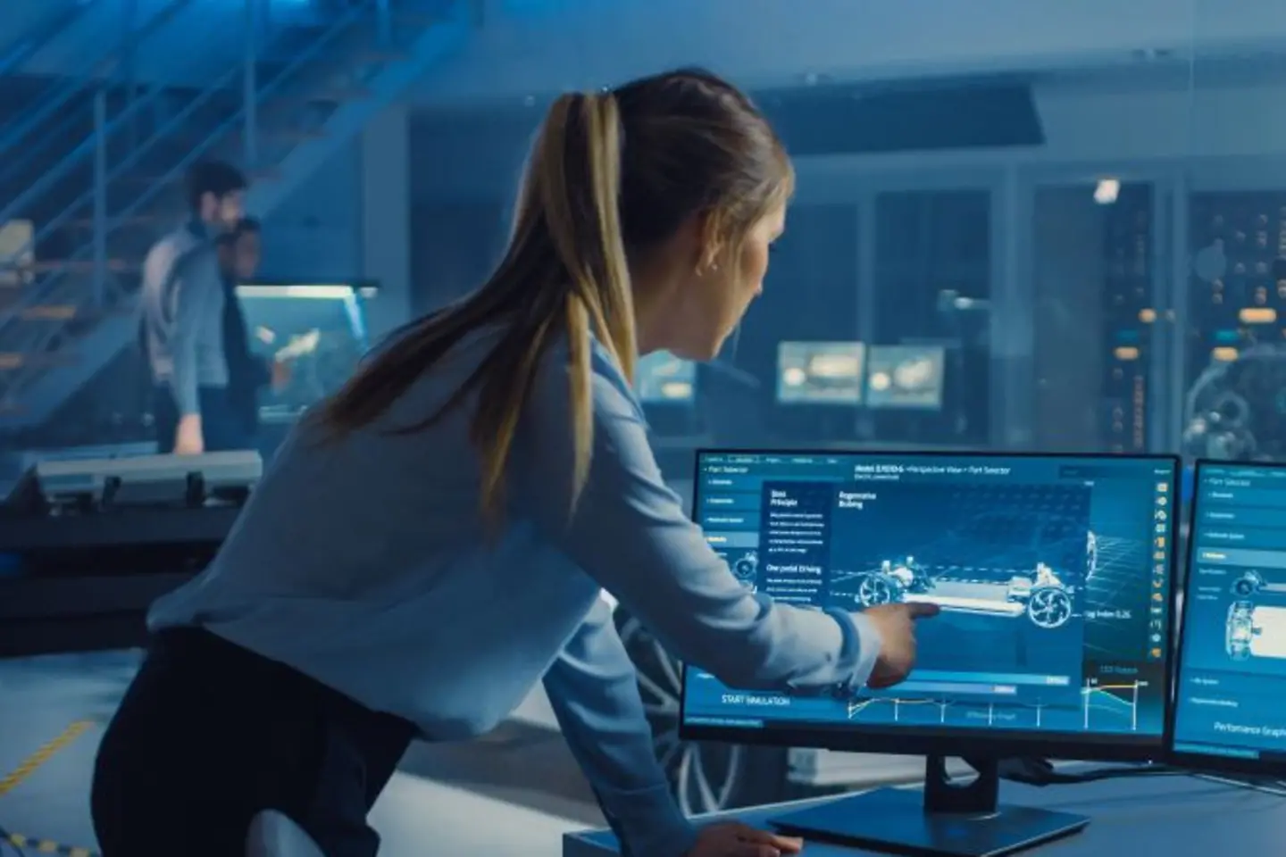 Female and male engineers discuss the 3D CAD software render of an electric Concet car.