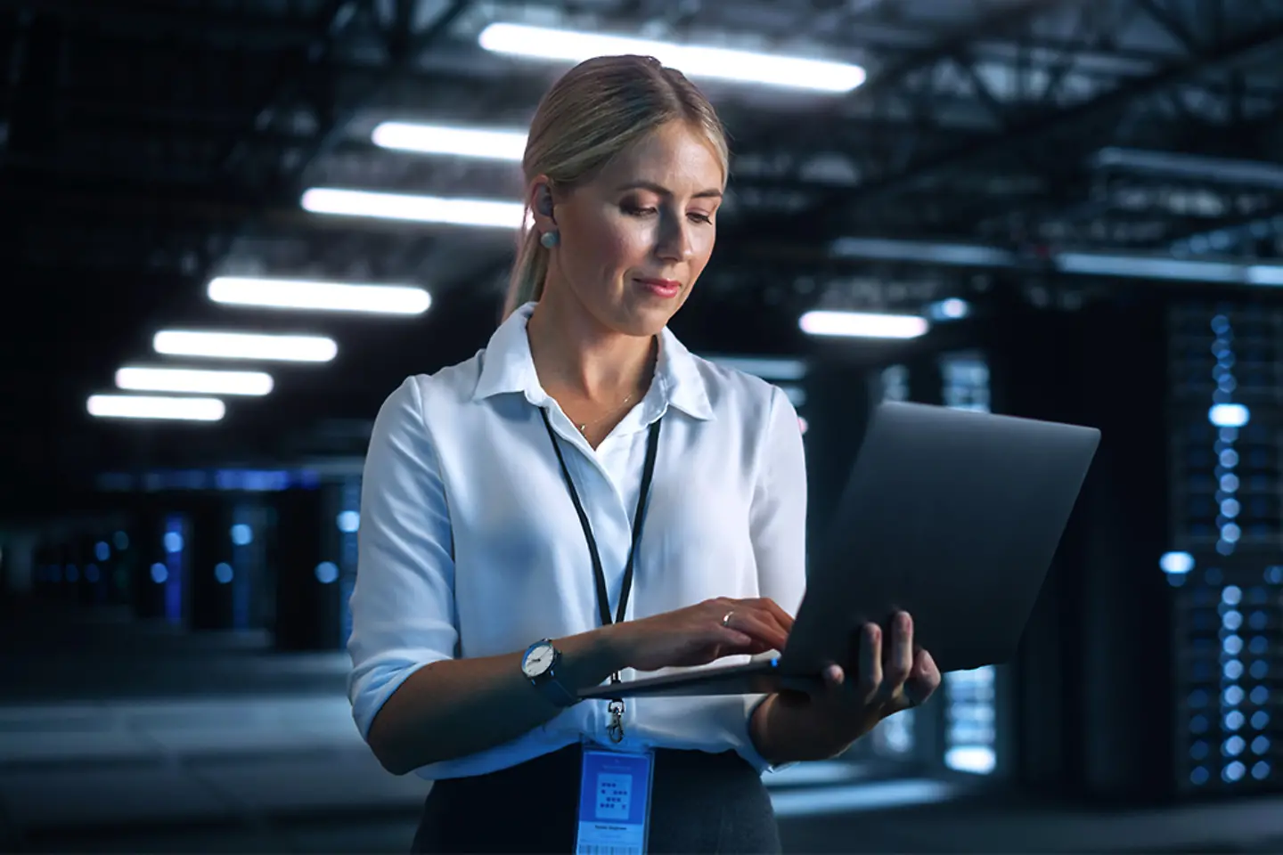 An engineer uses a laptop in a cloud computing facility at a server farm