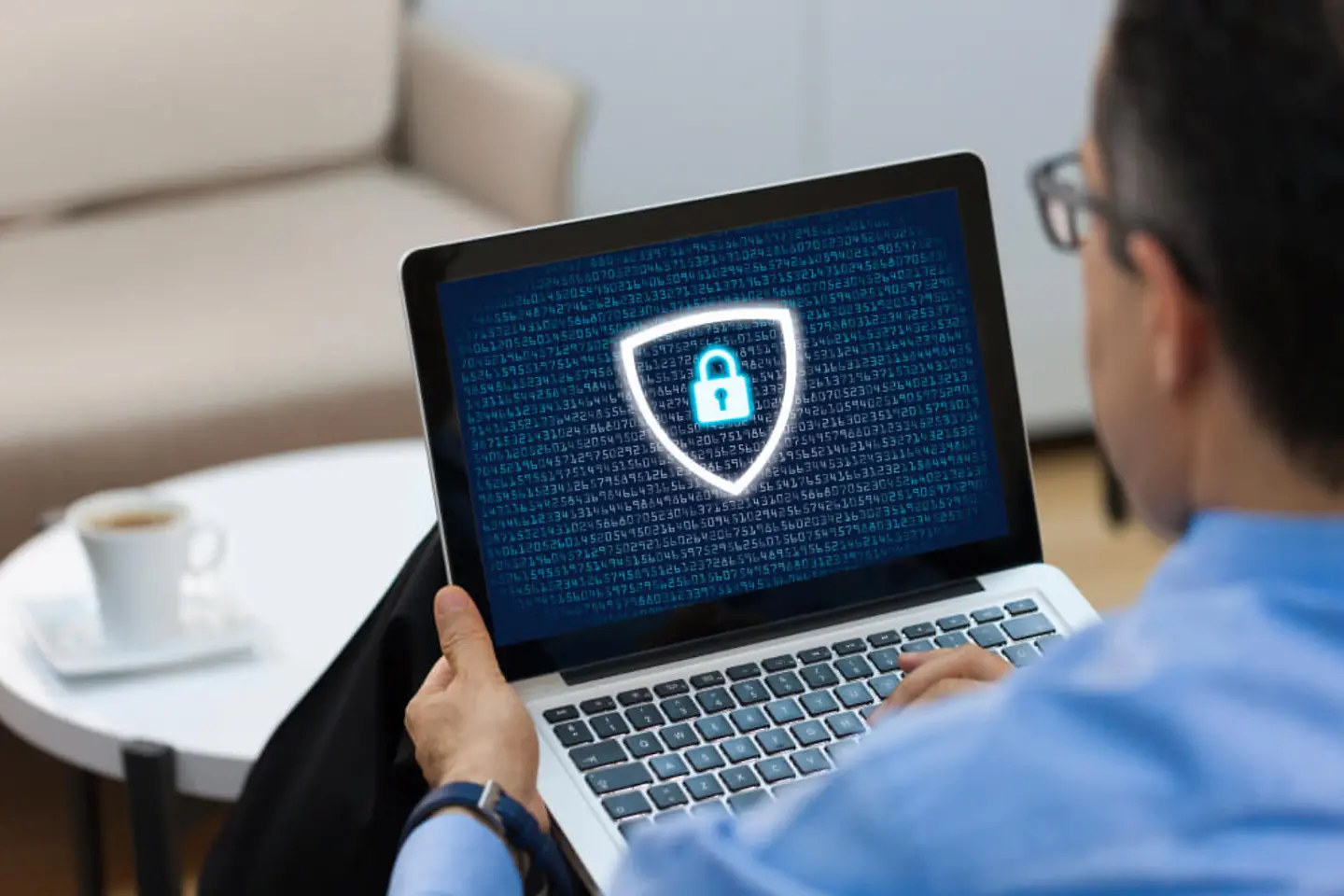 Man with a laptop, data protection logo on the screen.