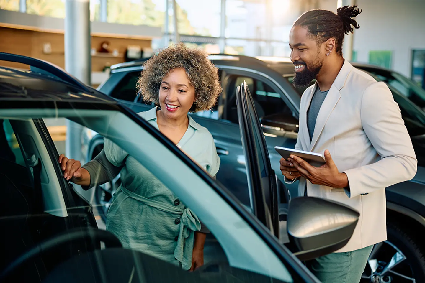 Cliente satisfecho comprando un coche nuevo con un vendedor en la sala de exposición