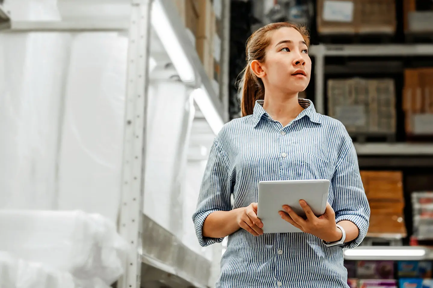 Warehouse worker with tablet in AU-controlled logistics hall