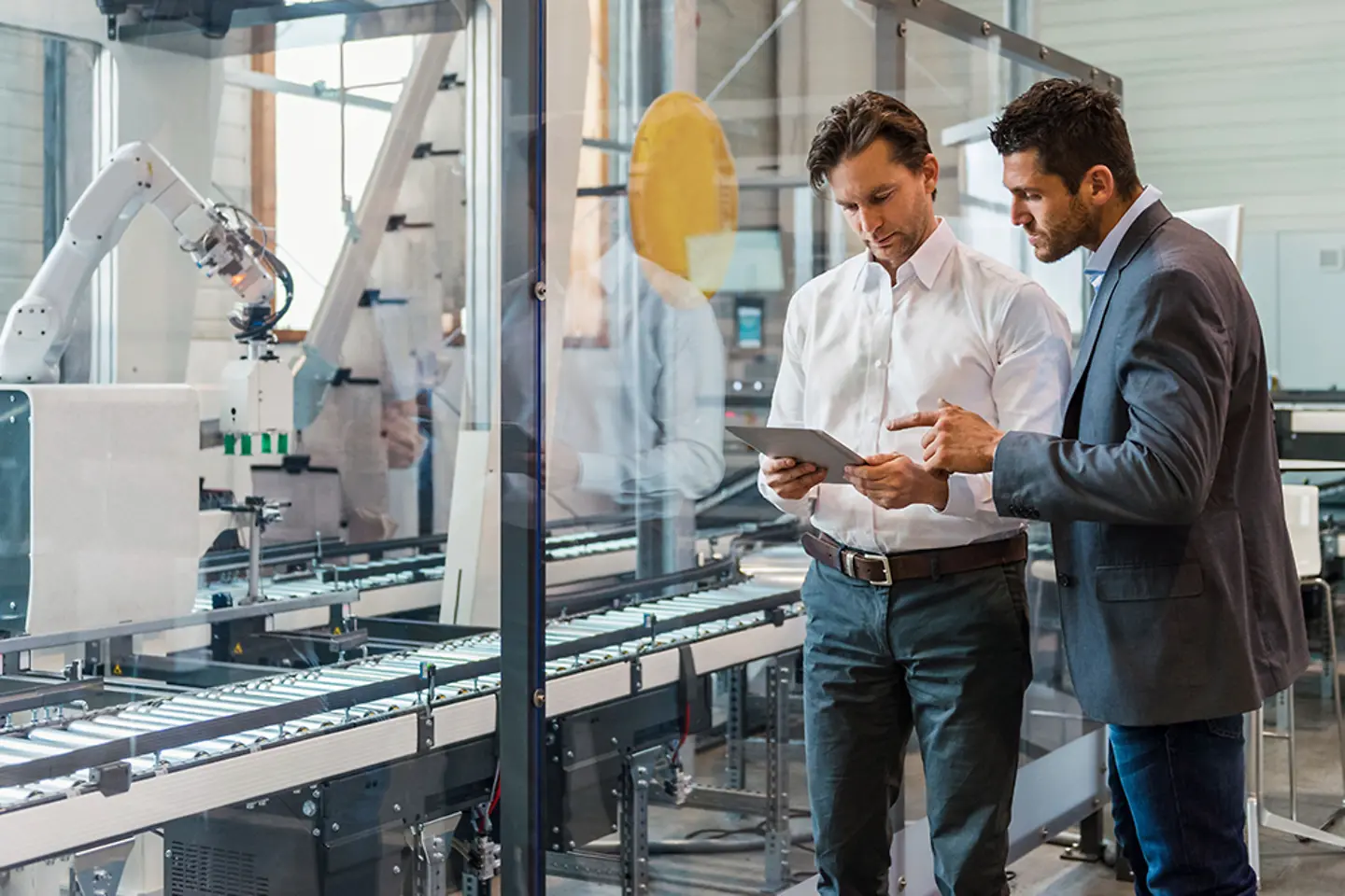 Two men working on tablet in factory