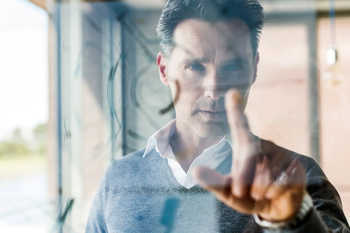 Businessman touching transparent projection screen