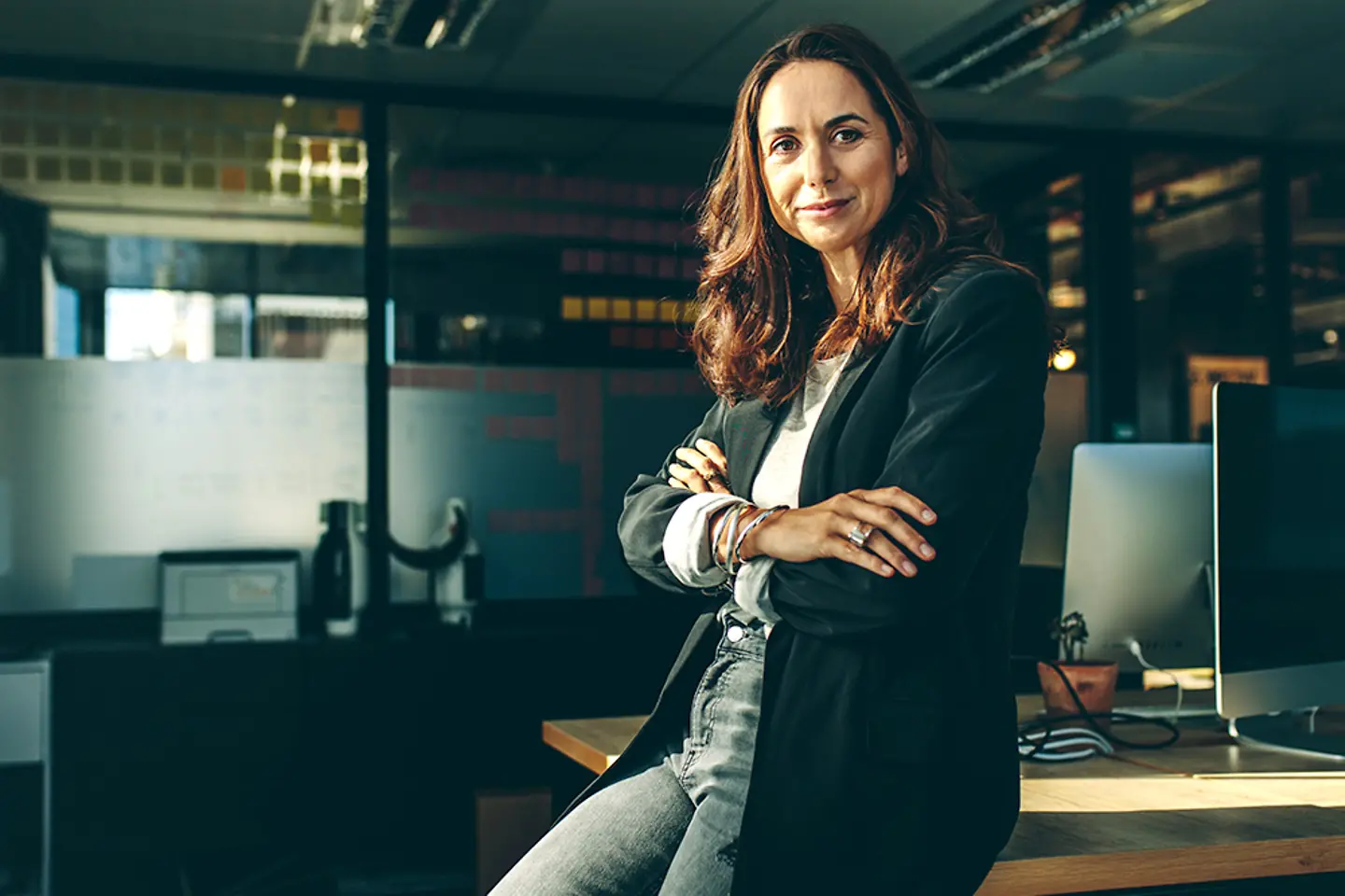A businesswoman sits on her desk.
