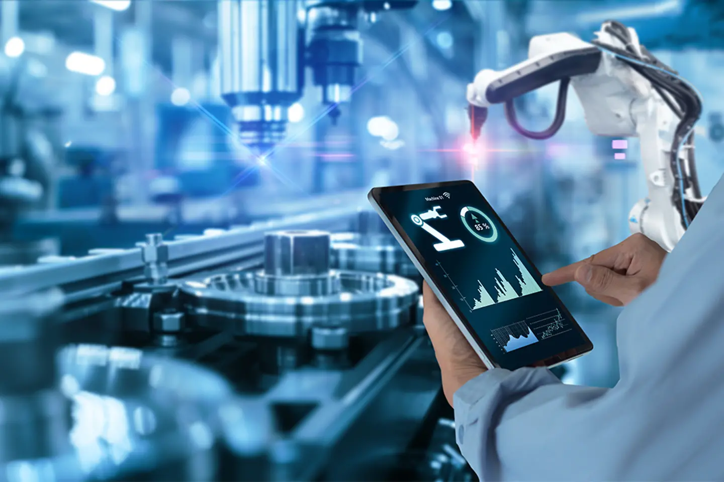 Hands holding tablet on blurred automation machine as background