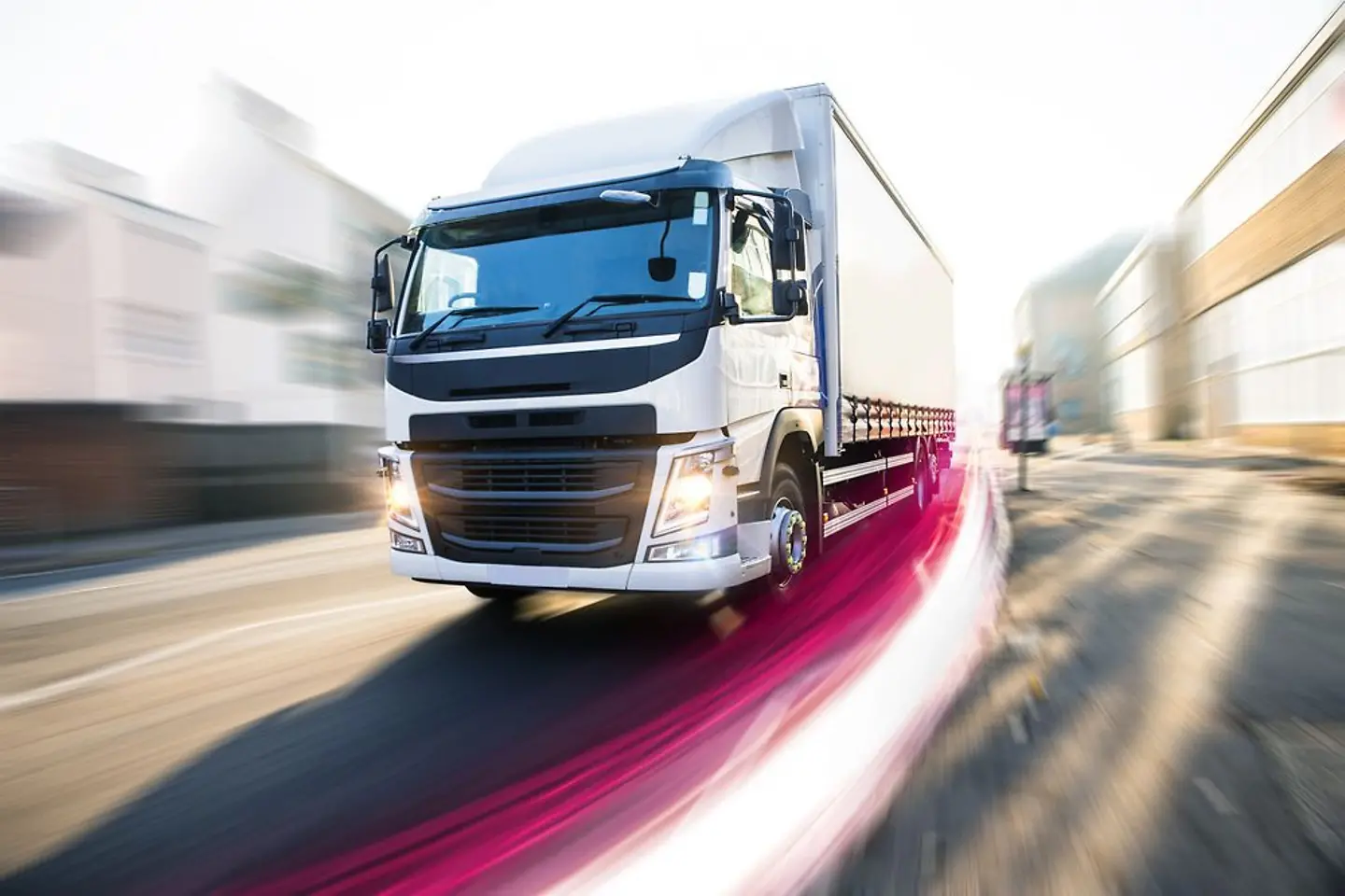 Asphalt highway with electronic toll gates in autumn woodland with trucks on road