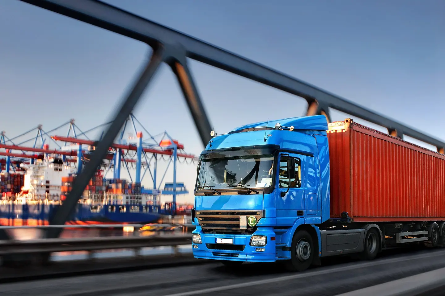 Lastwagen auf einer Brücke mit Hafen im Hintergrund