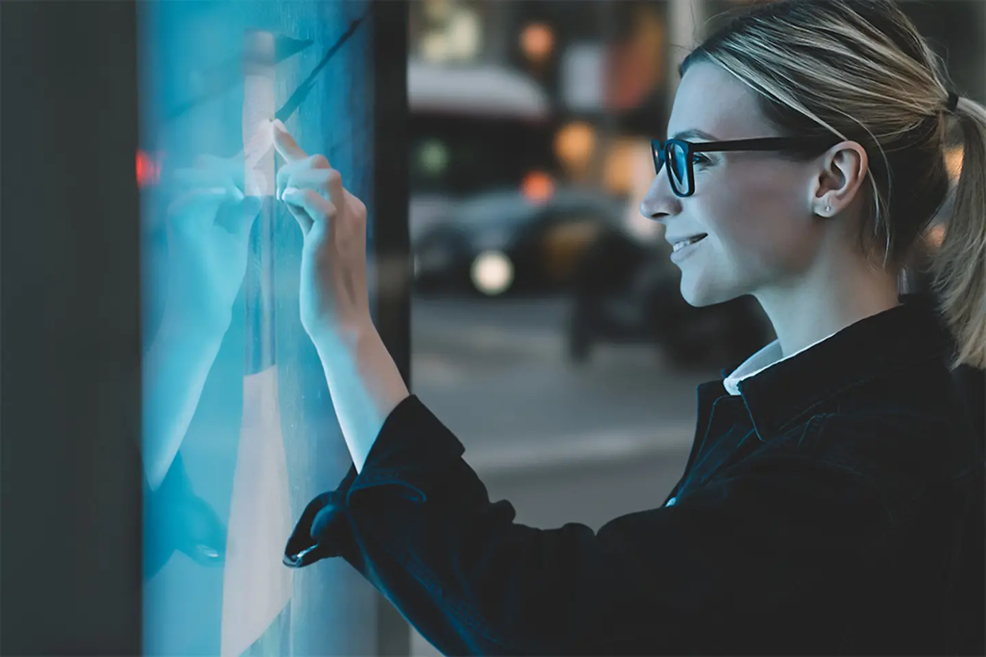 Young woman touching with finger a touchscreen display