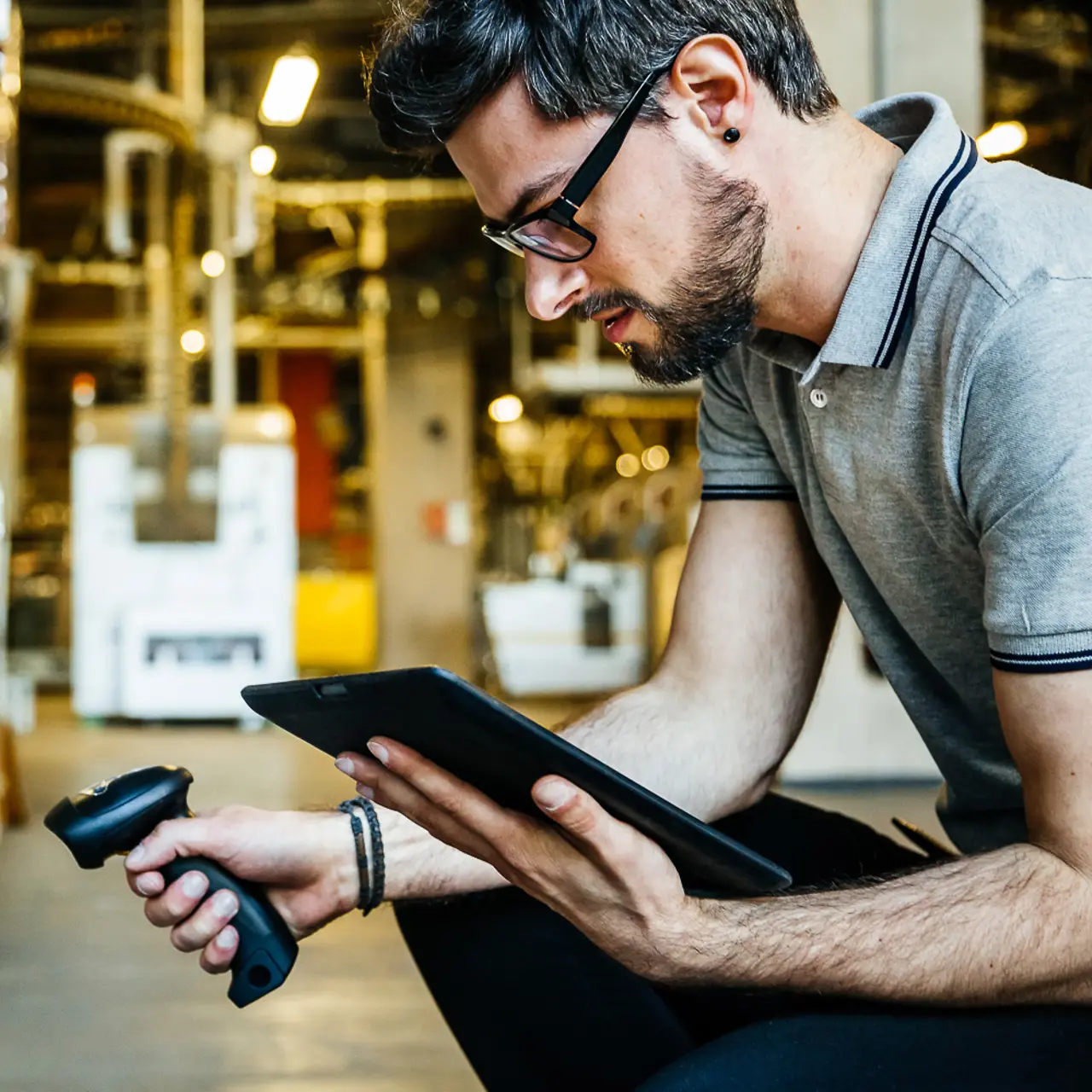 Factory worker scans goods and checks on tablet