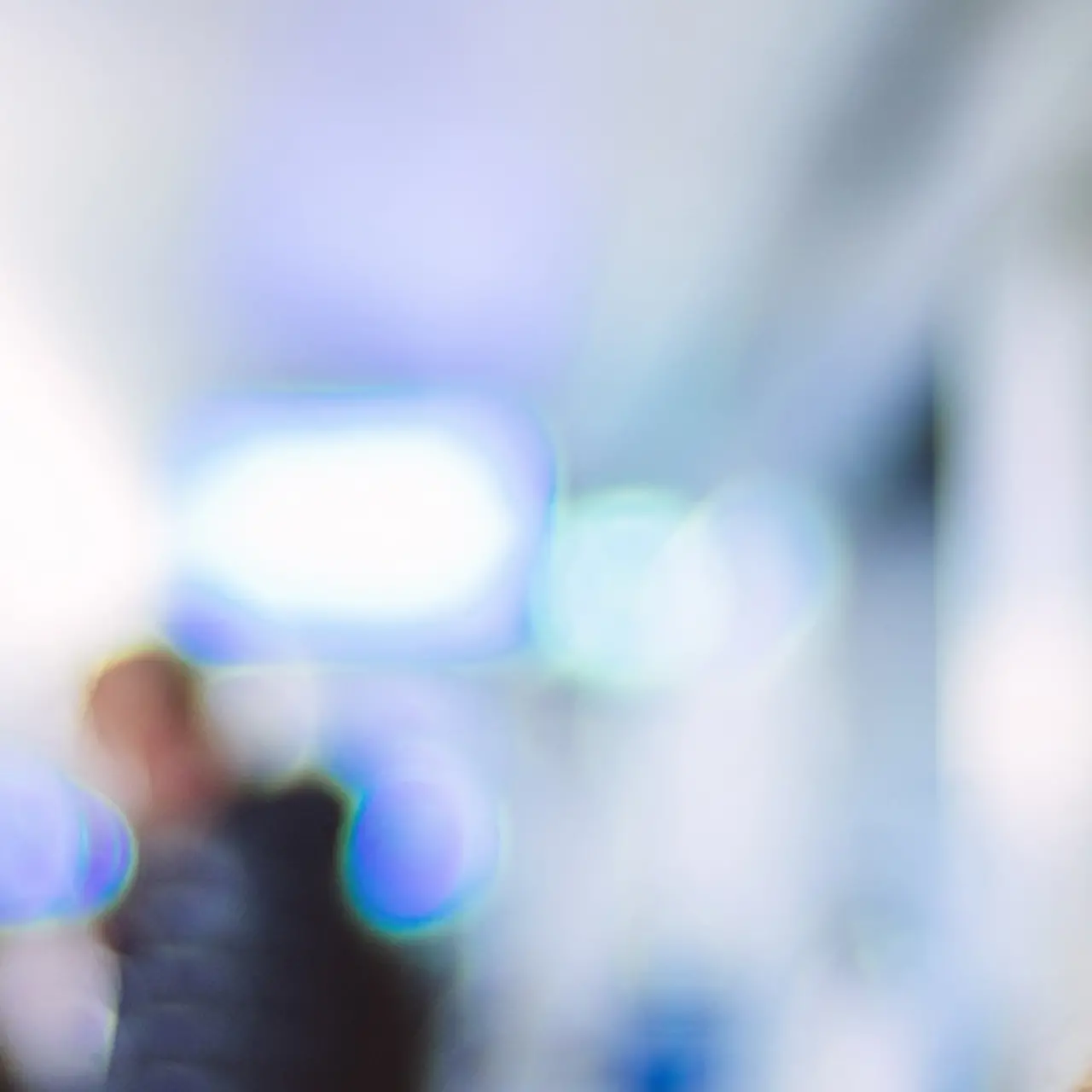  A woman wearing a face mask standing at a train station.