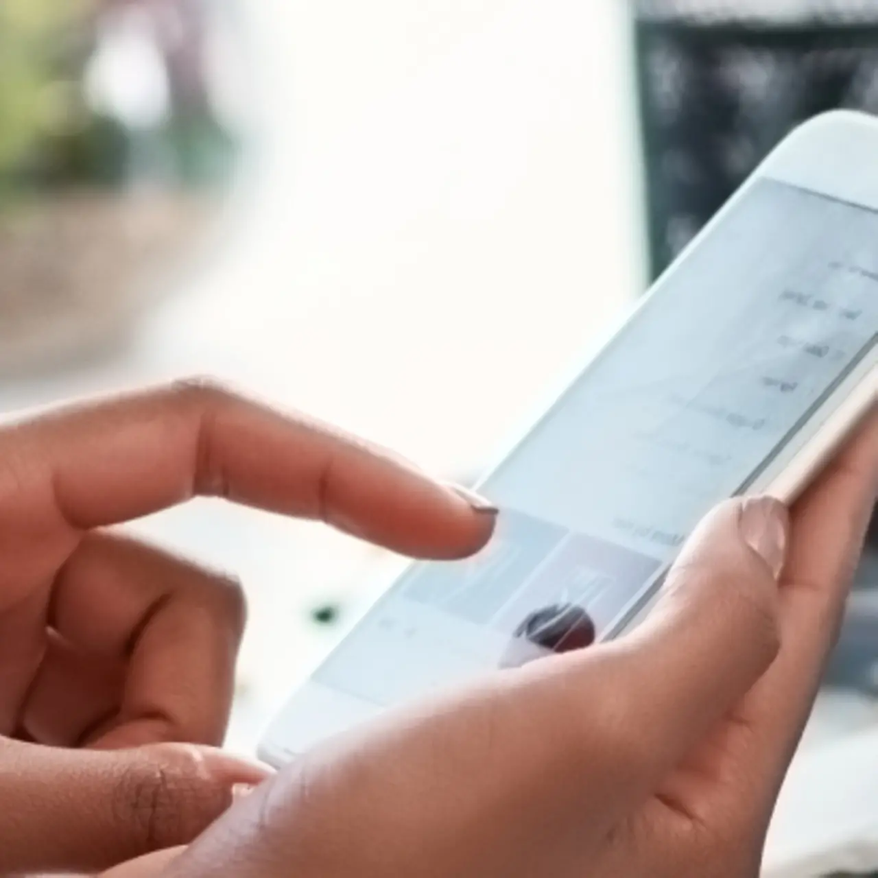 Hand with smartphone and laptop with graphs