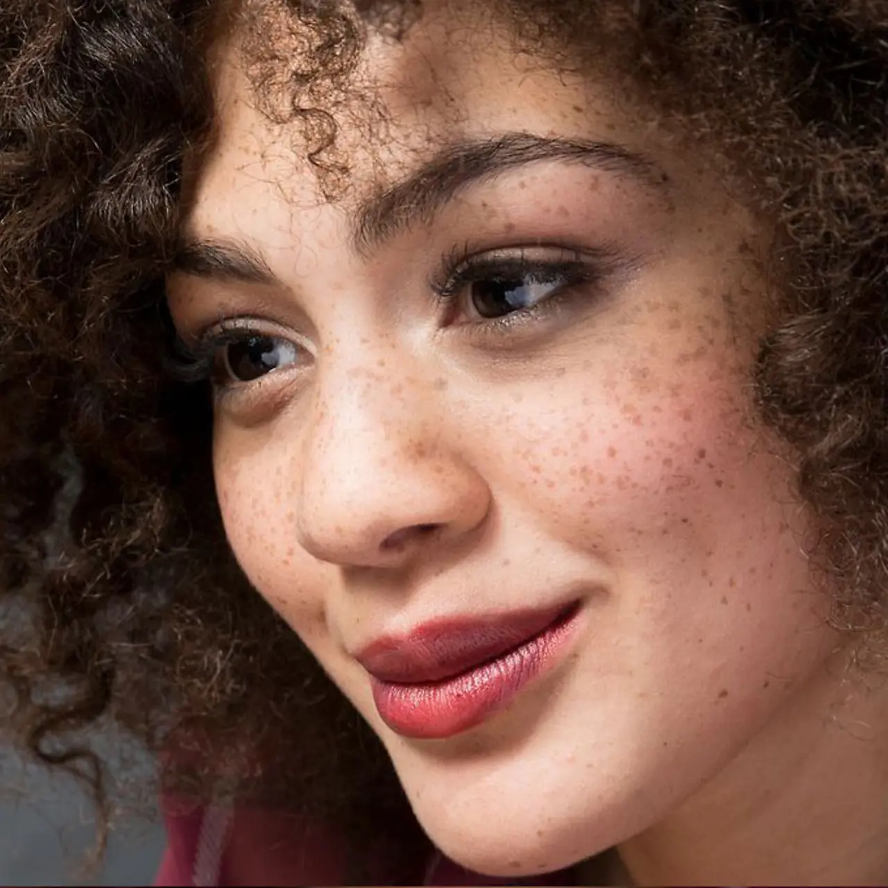 A woman looks at a computer with a smile.