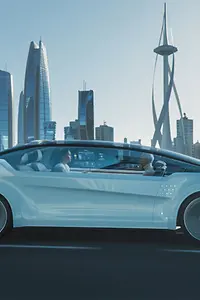 行驶在公路上的未来主义汽车的特写镜头，背景是摩天大楼