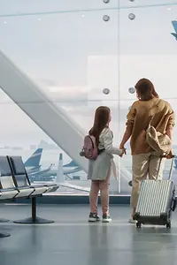 正在候机的母女俩望向窗外起落的飞机