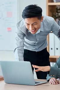 Empresários em frente a laptops estão felizes com o sucesso da segurança cibernética