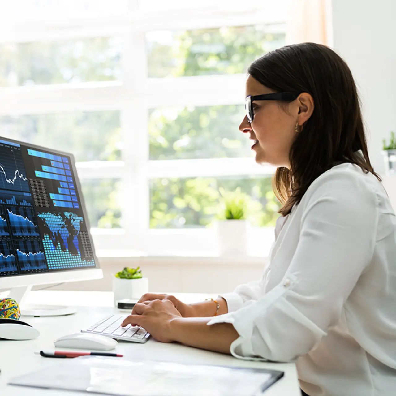 Empleada en la oficina en casa frente a una pantalla con datos