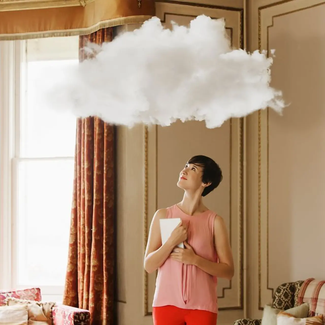 Woman with Laptop looking at a cloud above her head