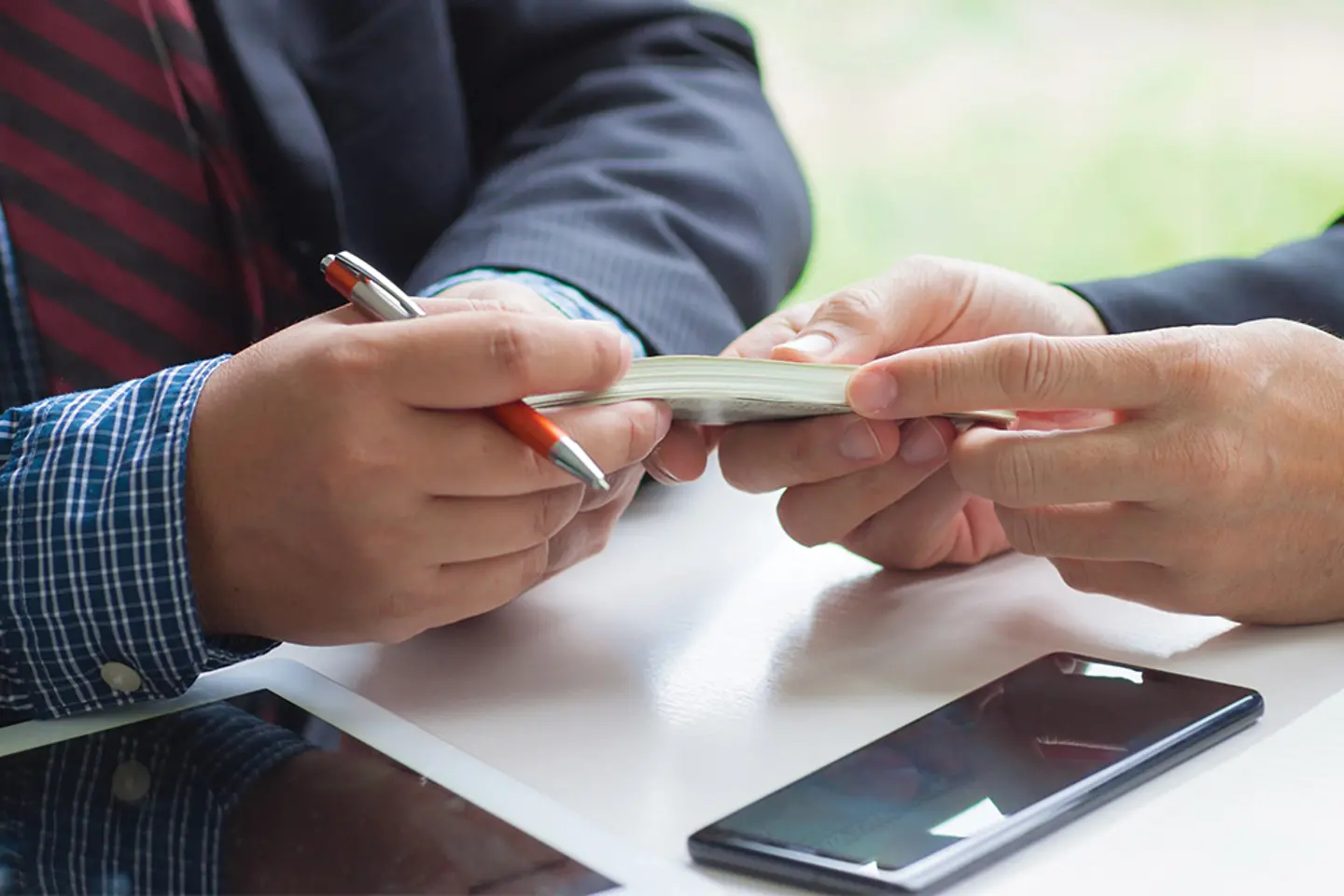 Um empresário entrega dinheiro a outro empresário