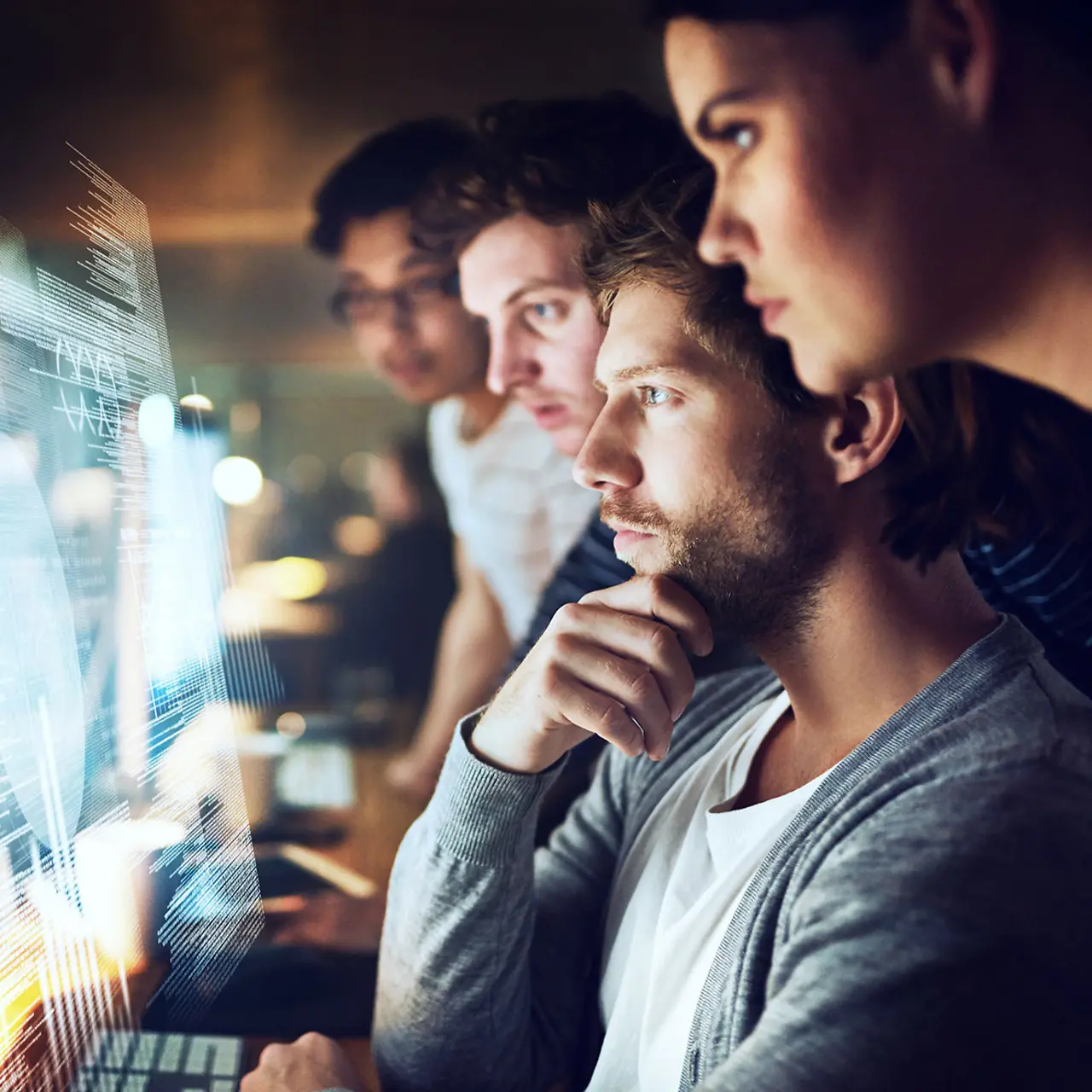 Trainees work together in front of several screens