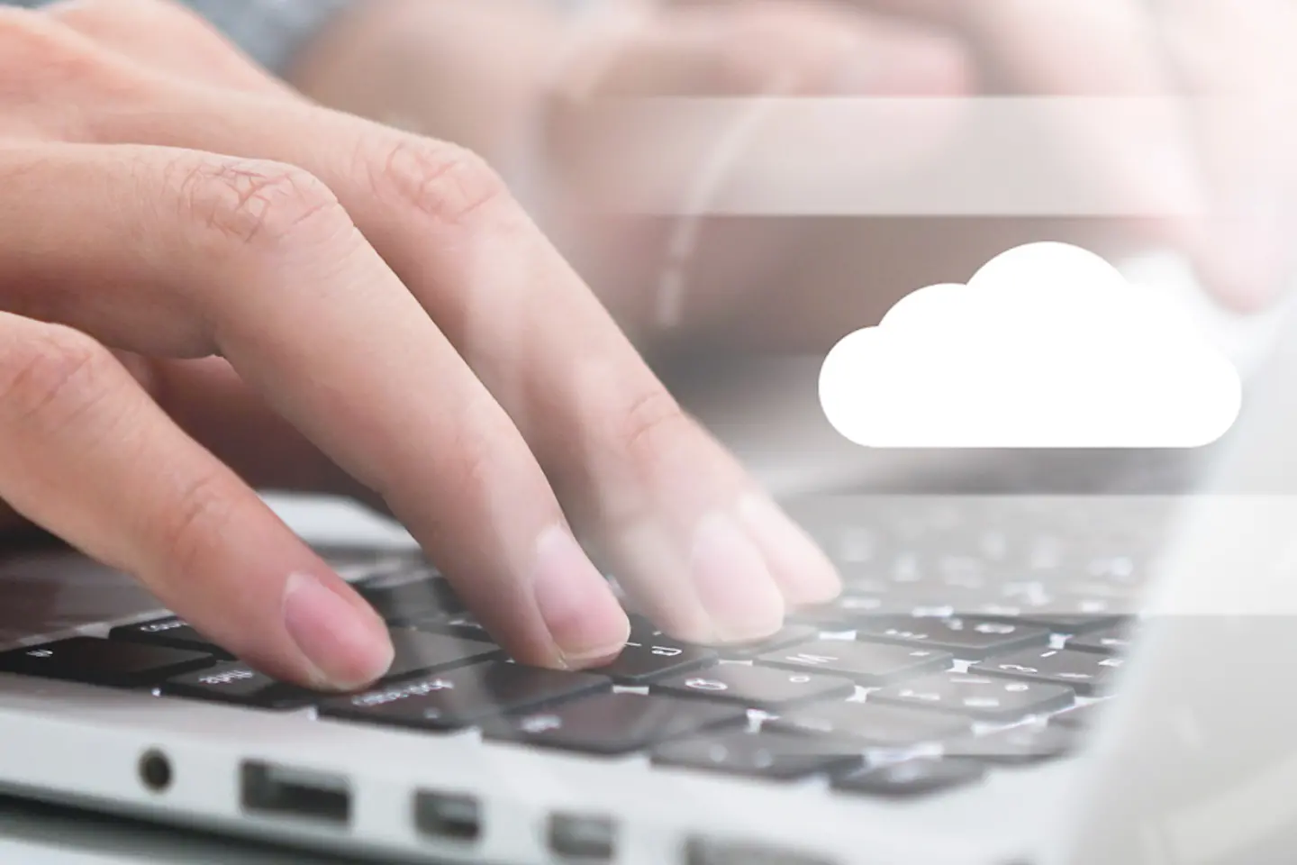 Hands typing on laptop keyboard