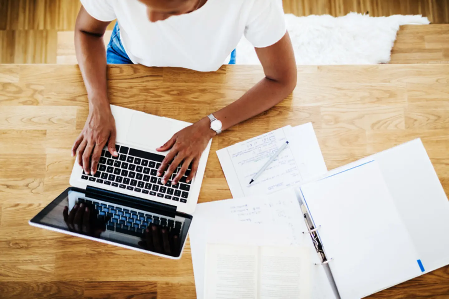 Aerial view of a woman working at a table by the laptop.