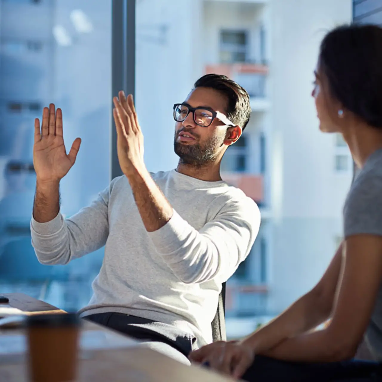 Young man explaining his vision to a young woman in the office