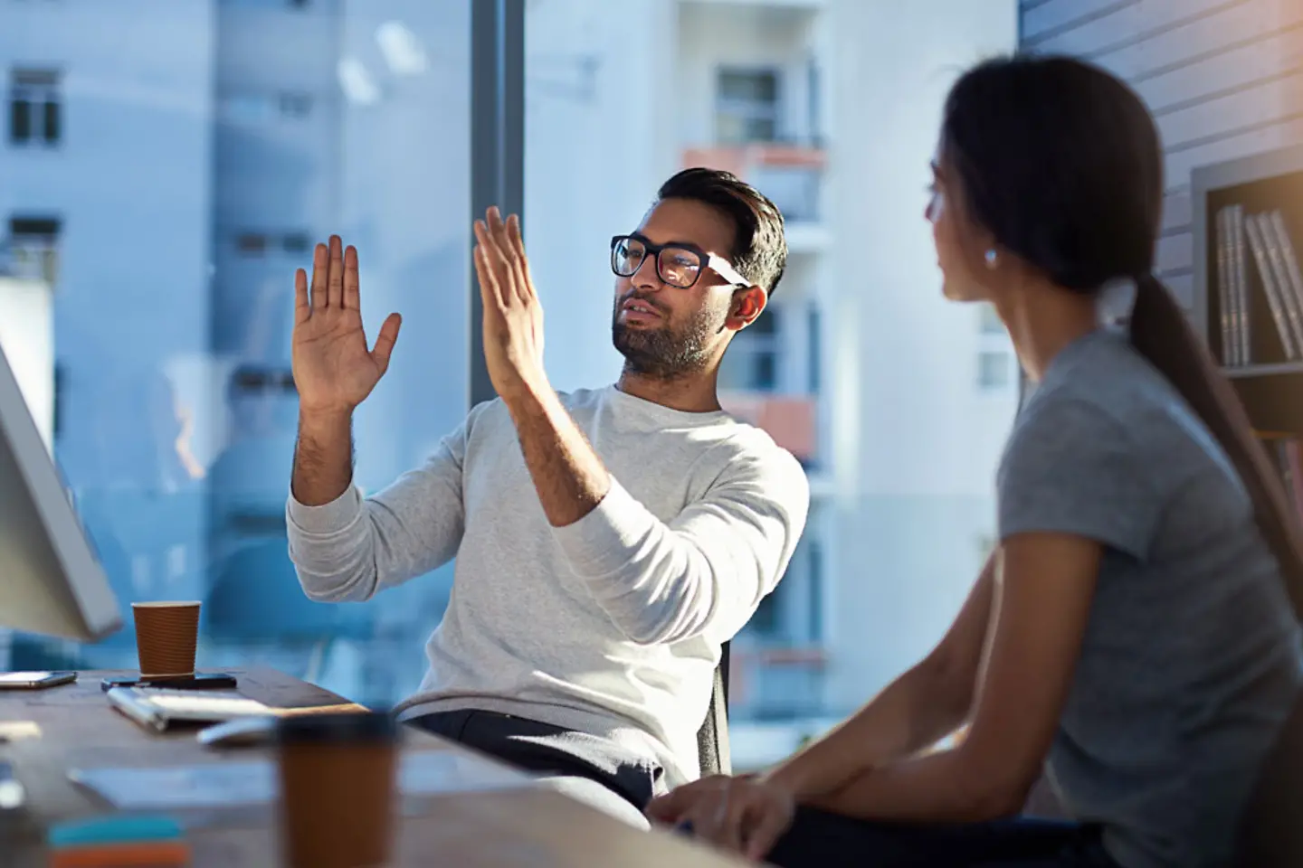 Young man explaining his vision to a young woman in the office