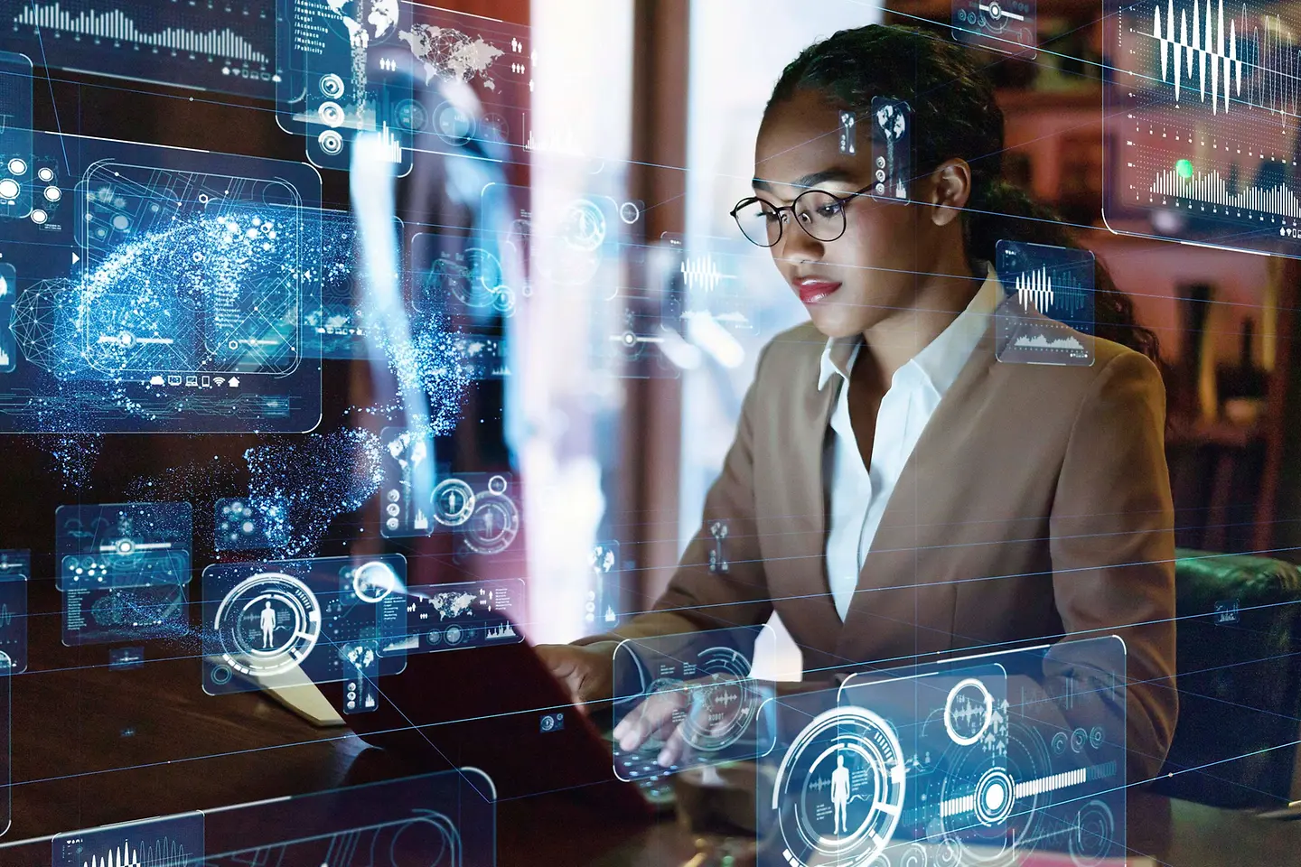 Mujer tecleando en un laptop con hologramas alrededor de ella